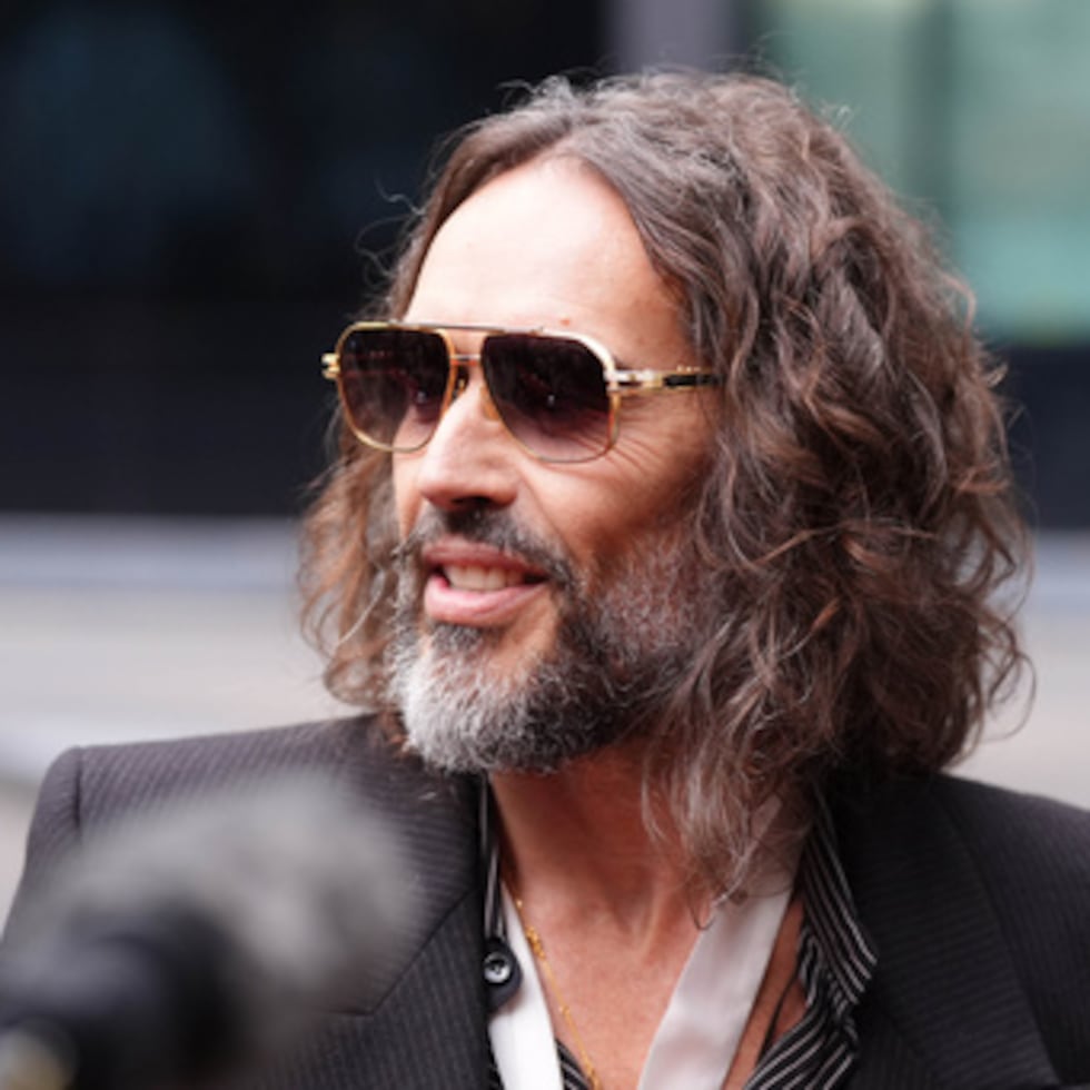 Russell Brand habla con los medios de comunicación a su llegada al Tribunal Penal de Southwark, en Londres, el miércoles 14 de octubre de 2026. (Ben Whitley/PA vía AP)