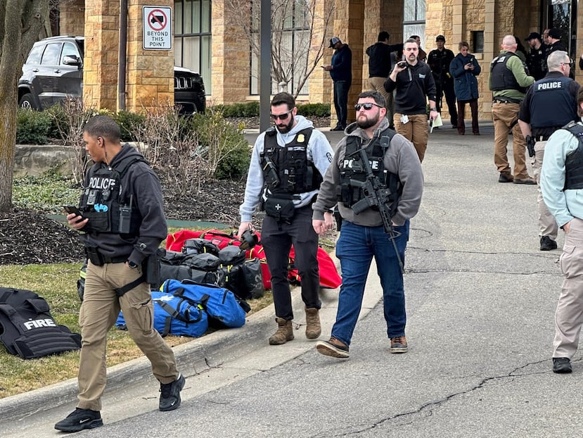 A woman gathers children as law enforcement respond to a call at Temple Israel synagogue on Thursday, March 12, 2026, in West Bloomfield Township, Mich. (AP Photo/Corey Williams)