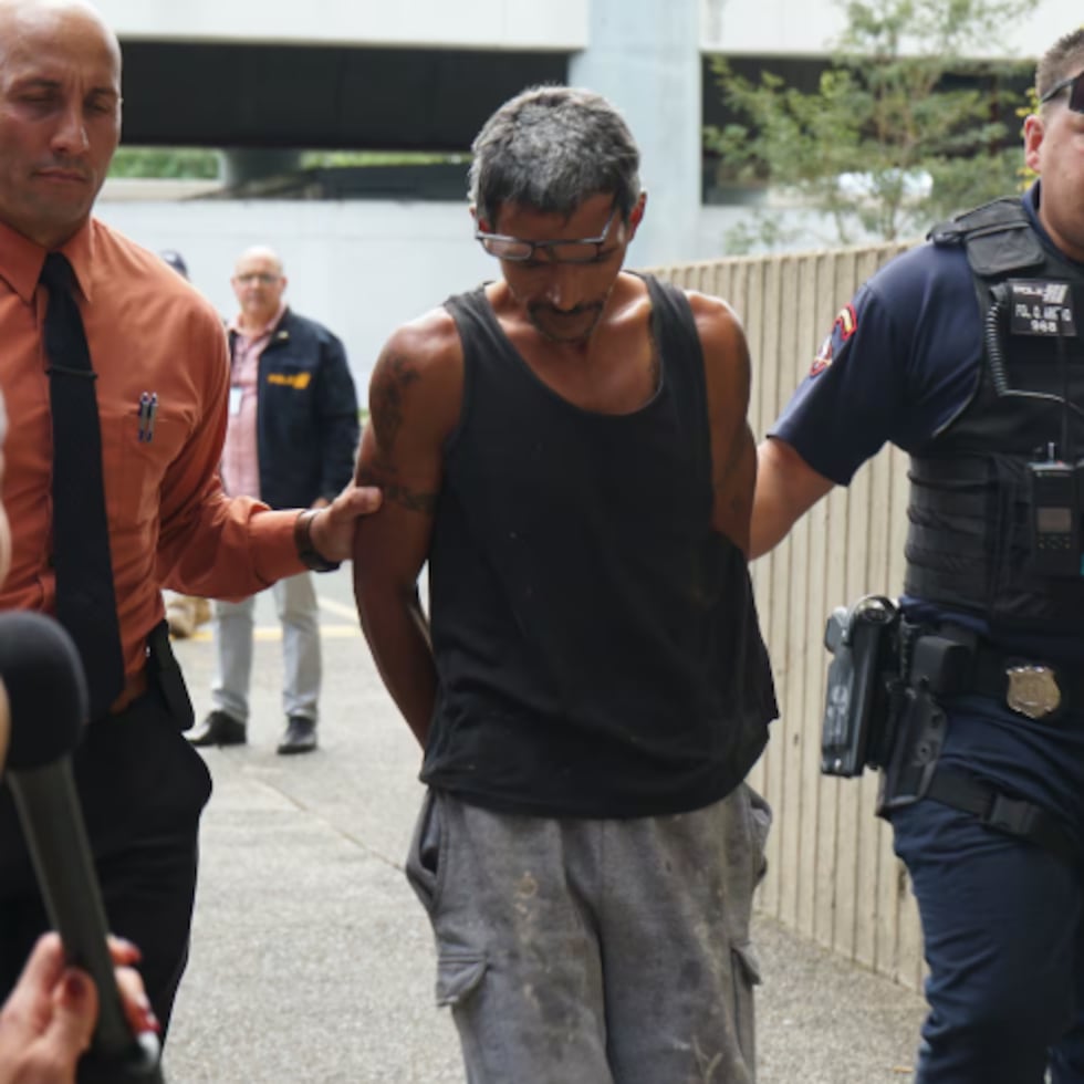 Luis E. Meléndez Pagán, de 50 años, padre de la menor que denunció un patrón de maltrato en Toa Baja, llega esposado y escoltado por agentes de la Policía al Tribunal de Bayamón.