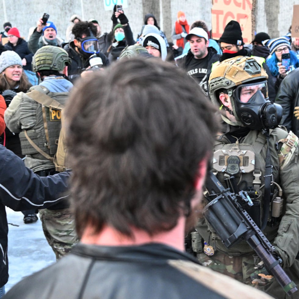 Federal agents confront protesters outside the Bishop Henry Whipple Federal Building, Thursday, Jan. 8, 2026, in Minneapolis, Minn. (AP Photo/Tom Baker)