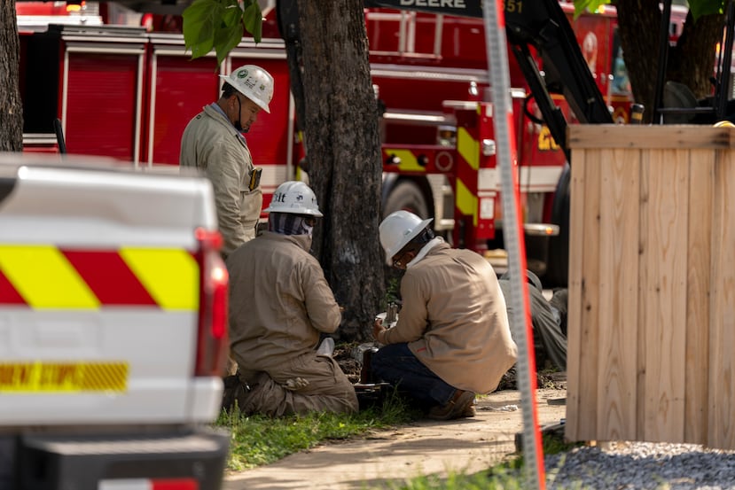 Atmos Energy employees work at the scene of a large fire at an apartment complex in Dallas, Thursday, May 28, 2026. (AP Photo/Gabriela Passos)