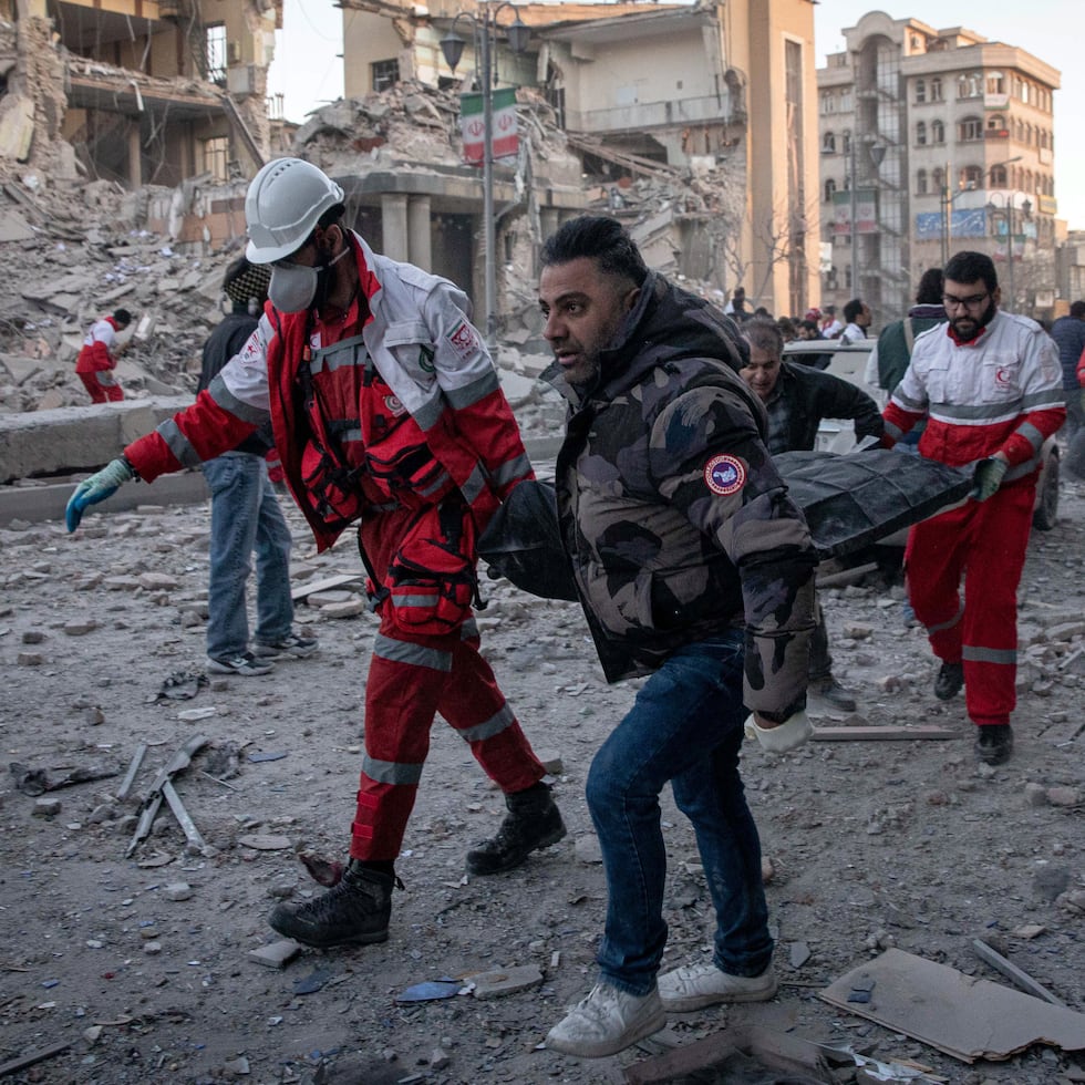 Personal médico retira un cadáver tras un ataque a un edificio en la plaza Enghelab de Teherán, Irán.