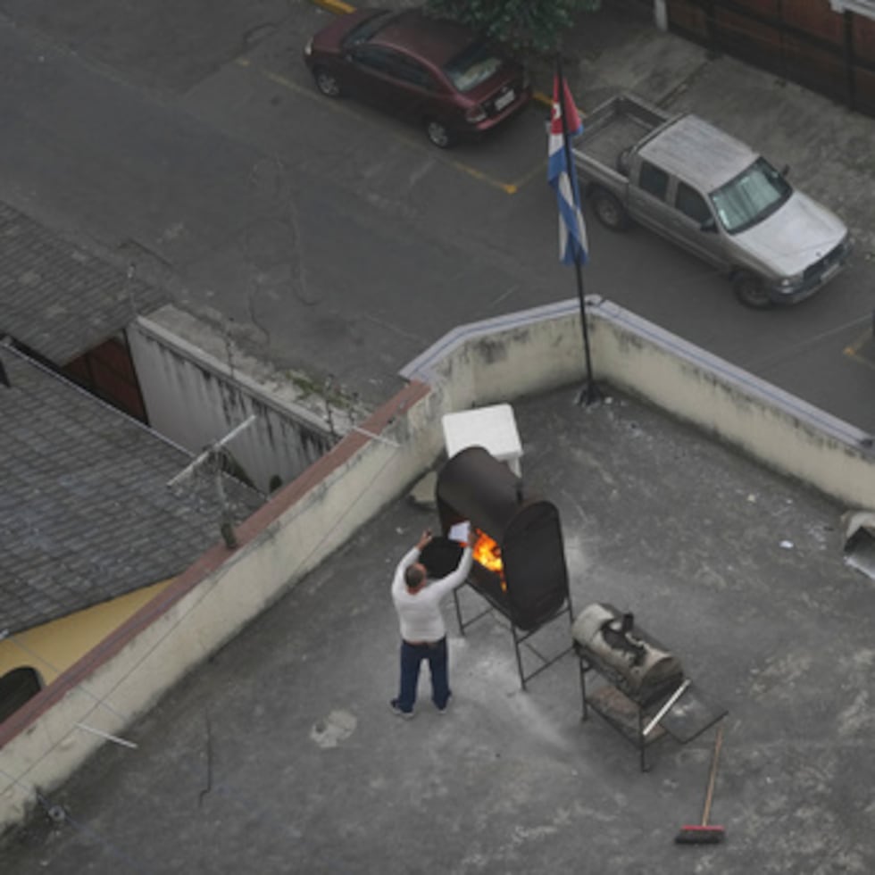 Un hombre quema papeles en un techo de la Embajada de Cuba en Quito, Ecuador, el miércoles 4 de marzo de 2026.