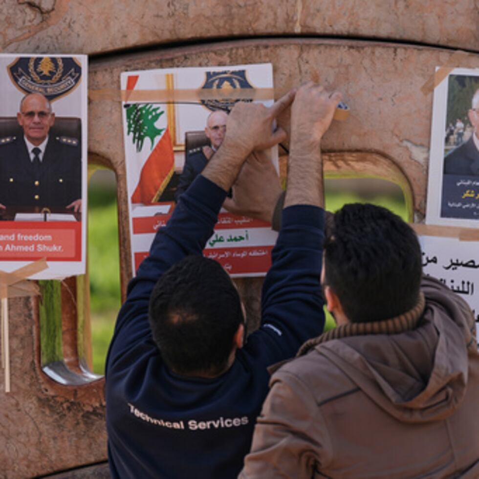 Familiares del oficial libanés retirado Ahmed Shukr, cuelgan carteles suyos durante una concentración frente a la sede de la Comisión Económica y Social de las Naciones Unidas para Asia Occidental, CESPAO, en Beirut, Líbano, el viernes 13 de febrero de 2026. (AP Photo/Bilal Hussein)
