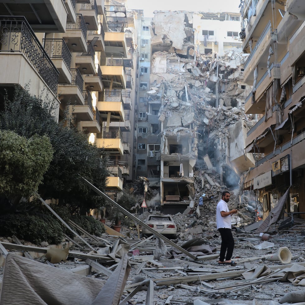 Un hombre inspecciona el lugar de los edificios destruidos que fueron alcanzados en ataques aéreos israelíes en la ciudad portuaria sureña de Tiro, Líbano.
