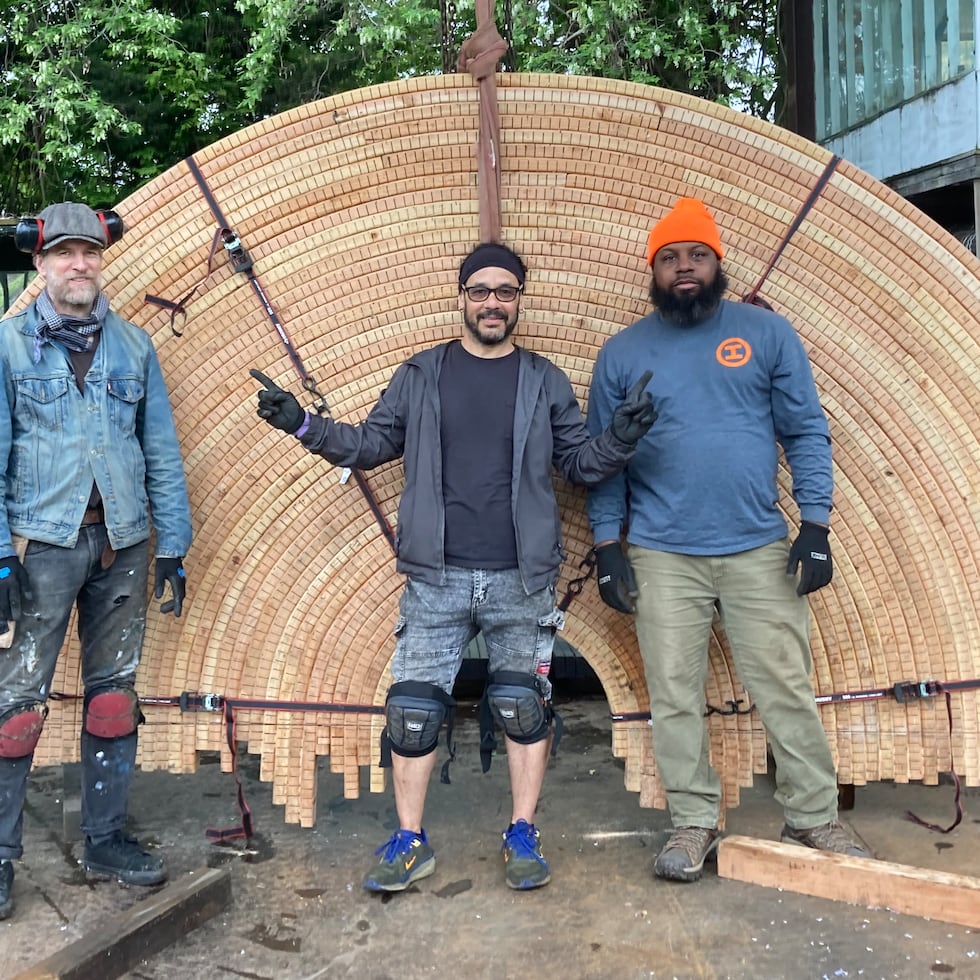 De izquierda a derecha Richard Webb, asistente en la construcción de la obra; Josué Guarionex, escultor y creador de la "La Carreta Made a U-Turn", y Terrence McCutchen, gerente de tienda del Socrates Sculpture Park.