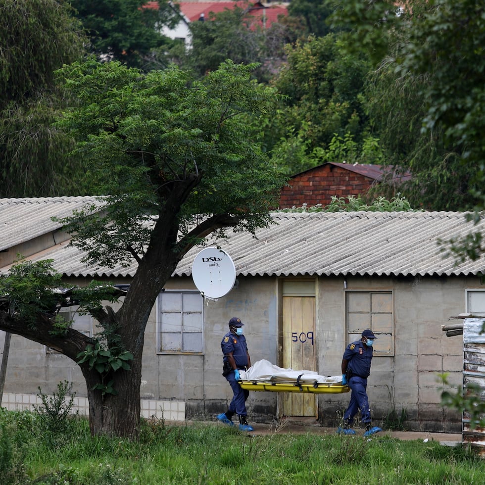 Agentes de policía cargan el cuerpo de una persona en una camilla tras un tiroteo en un bar cerca de Pretoria, Sudáfrica, el sábado 6 de diciembre de 2025.