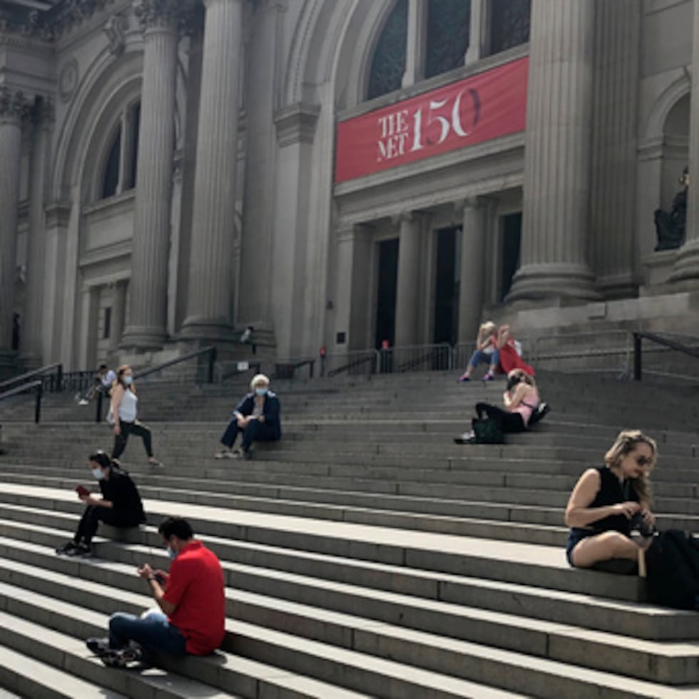 FILE - People sit outside the Metropolitan Museum of Art on May 2, 2020 in New York. (AP Photo/Ron Blum, file)