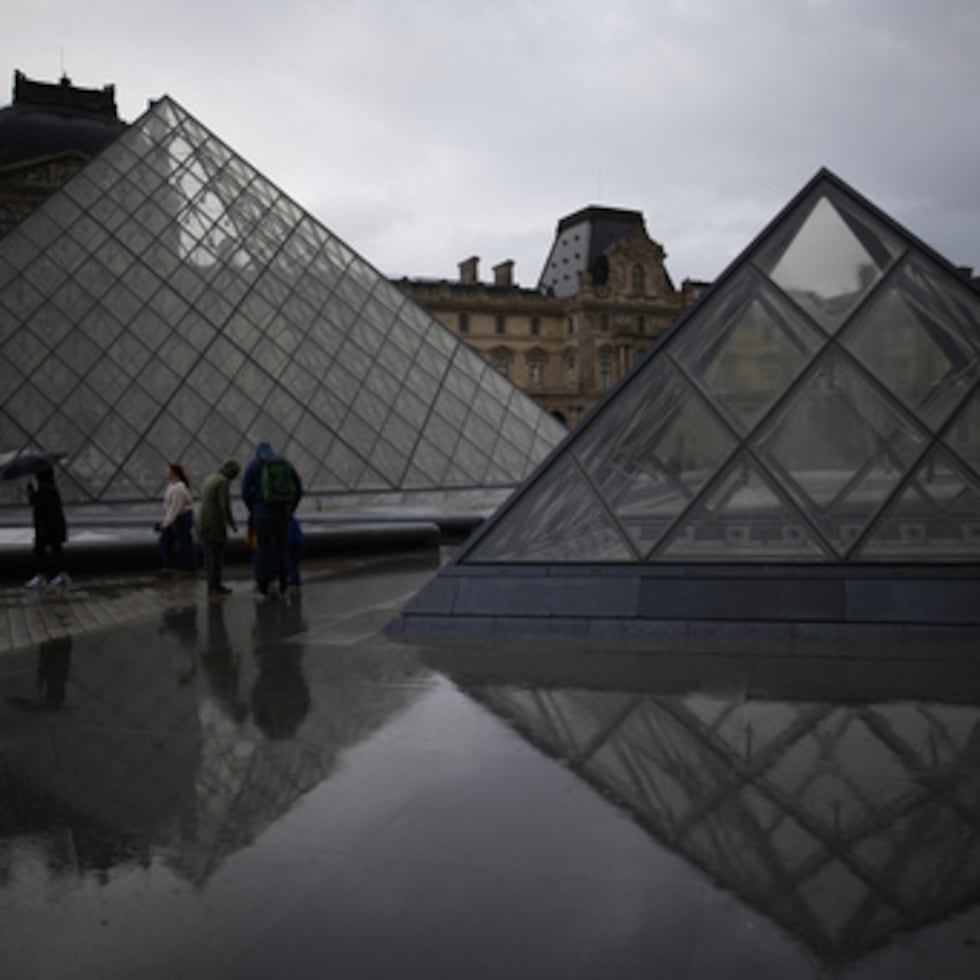 Turistas visitan el Louvre bajo la lluvia en París. #Louvre #Paris #Turismo