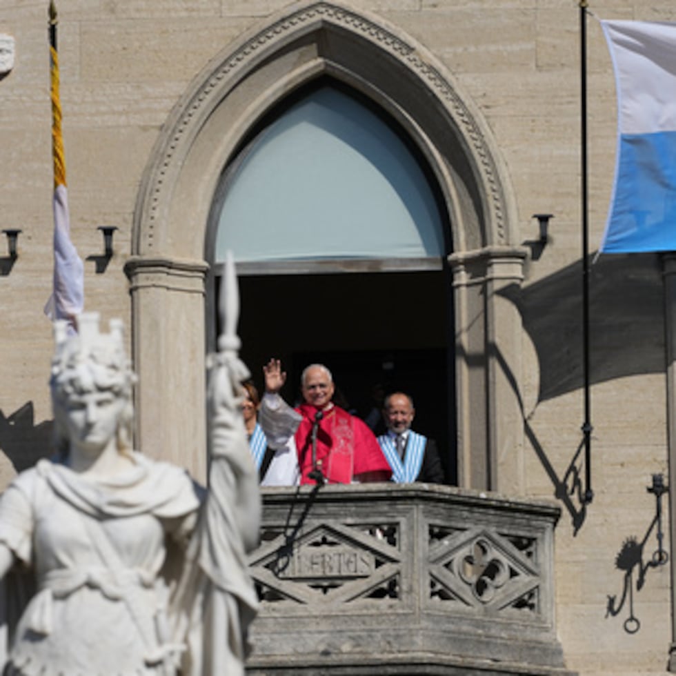 El papa León XIV, en el centro, flanqueado por los capitanes regentes Alice Mina, a la izquierda, y Vladimiro Selva, saluda a los fieles desde el balcón del Palazzo Pubblico.