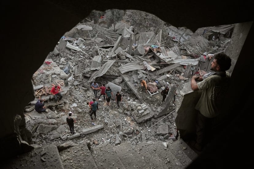 Palestinos inspeccionan un edificio destruido por un ataque aéreo israelí la noche del sábado en Zawaida, en el centro de la Franja de Gaza.