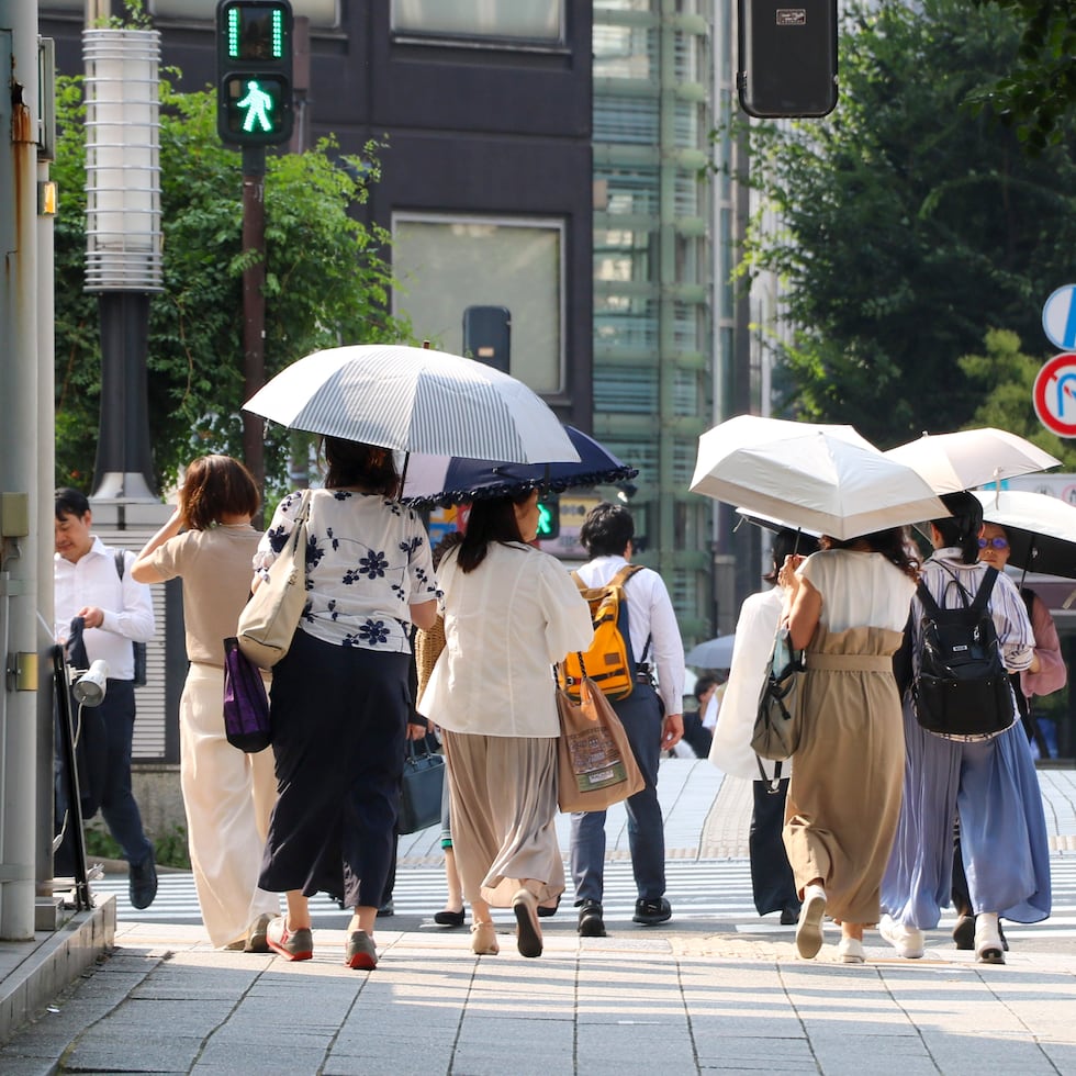 Varias mujeres se protegen con paraguas del calor mientras caminan por una calle de Tokio, que el pasado jueves afrontó una de sus jornadas más calurosas, en medio de una ola de temperaturas extremas que ha dejado 14 muertos y un récord de más de 10.000 hospitalizados en una semana.