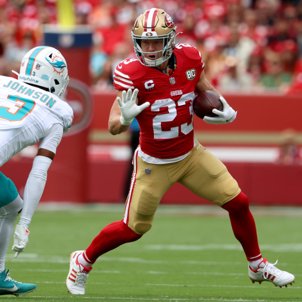El running back de los 49ers de San Francisco, Christian McCaffrey (23), corre ante el esquinero de los Dolphins de Miami, Chris Johnson.