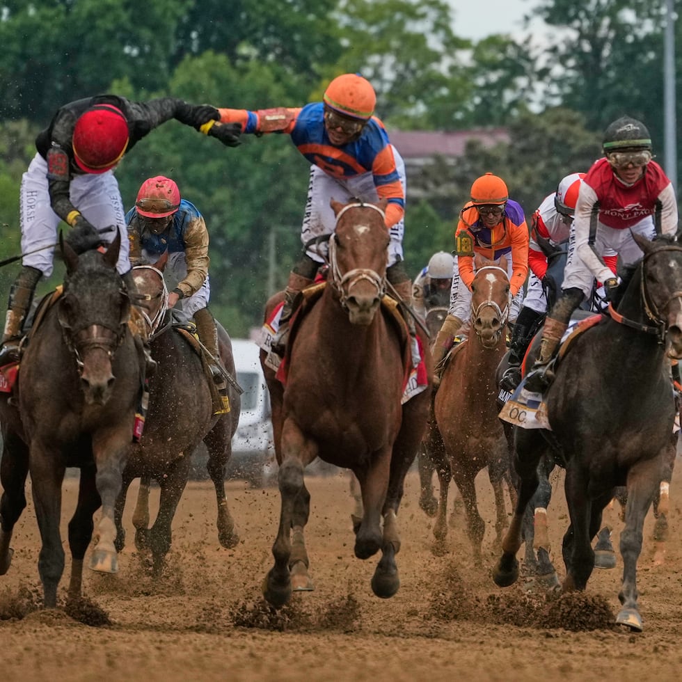 Este es el momento en que Irad Ortiz —a la derecha— le extiende el brazo a su hermano José Luis para felicitarlo por ganar el Derby el sábado en el hipódromo Churchill Downs.