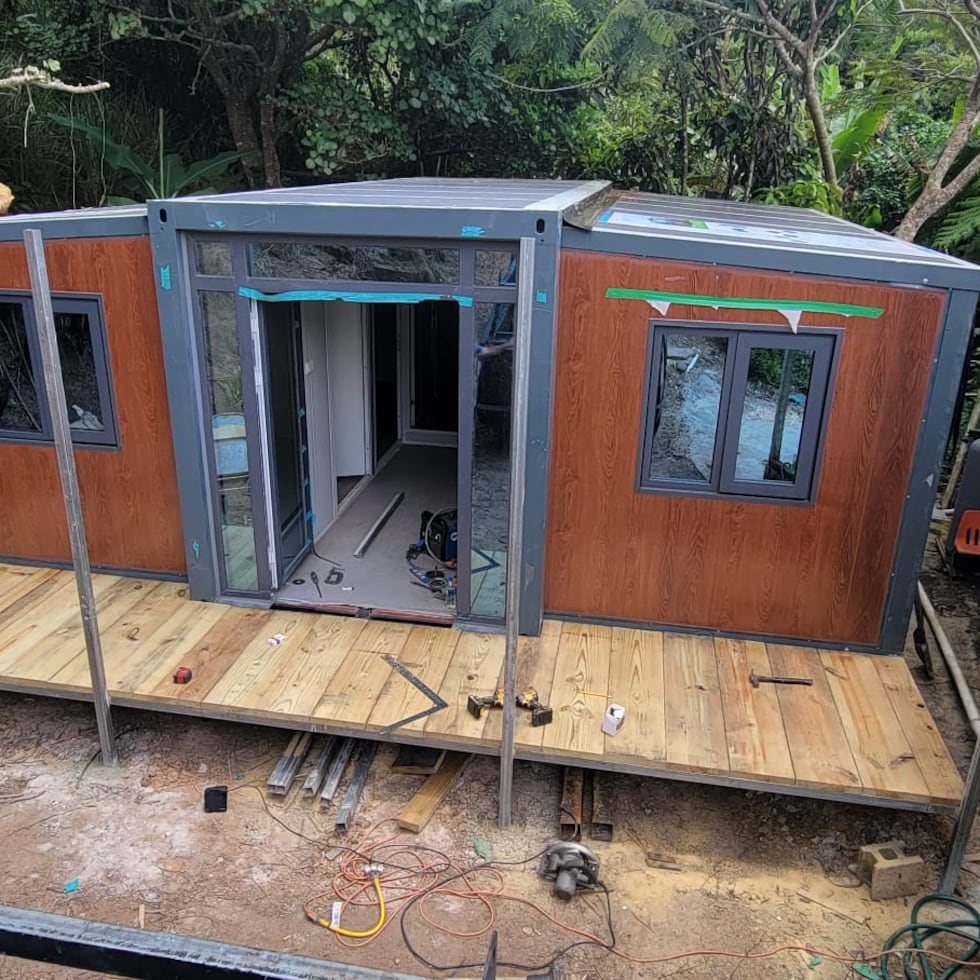 A la izquierda, una de las casas modulares del programa Dignidad Dorada, de Yauco, en proceso de instalación. A la derecha, se aprecia el deterioro de la vivienda de madera que, luego de terminada la instalación, se demolerá.