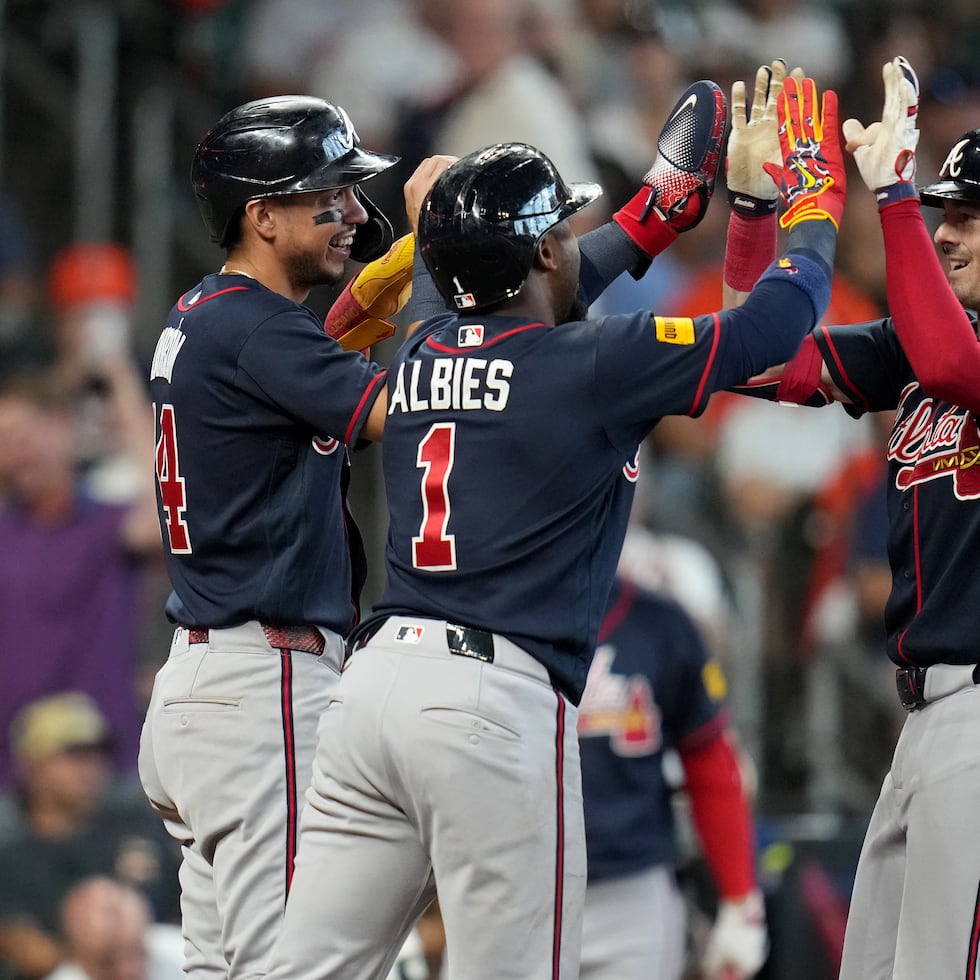 Mike Yastrzemski (derecha) celebra su cuadrangular de tres carreras con Mauricio Dubon (izquierda) y Ozzie Albies (centro) durante la sexta entrada del juego contra los Astros de Houston.