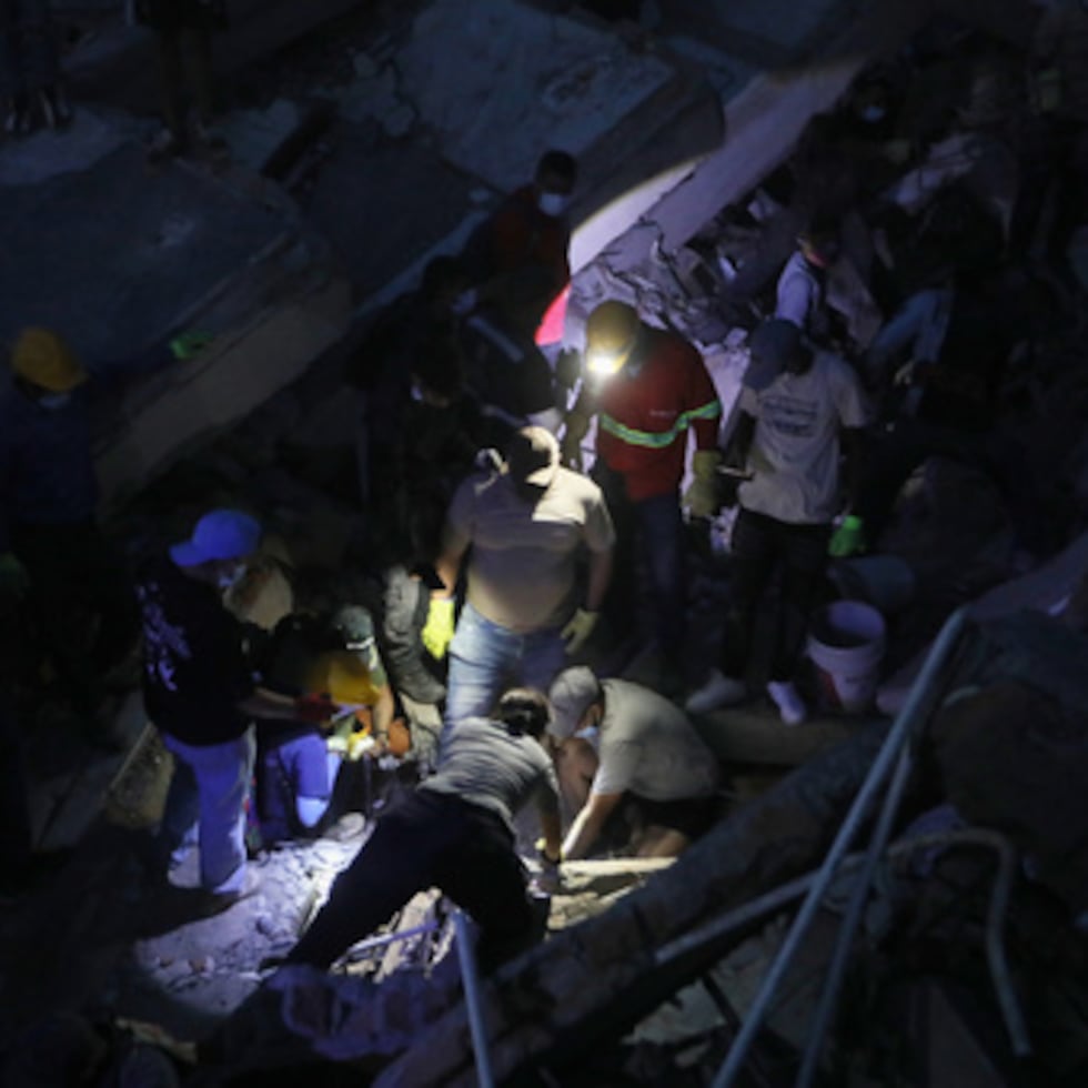 Varias personas buscan entre los escombros en una estructura desplomada en Cali tras el terremoto que sacudió Colombia.