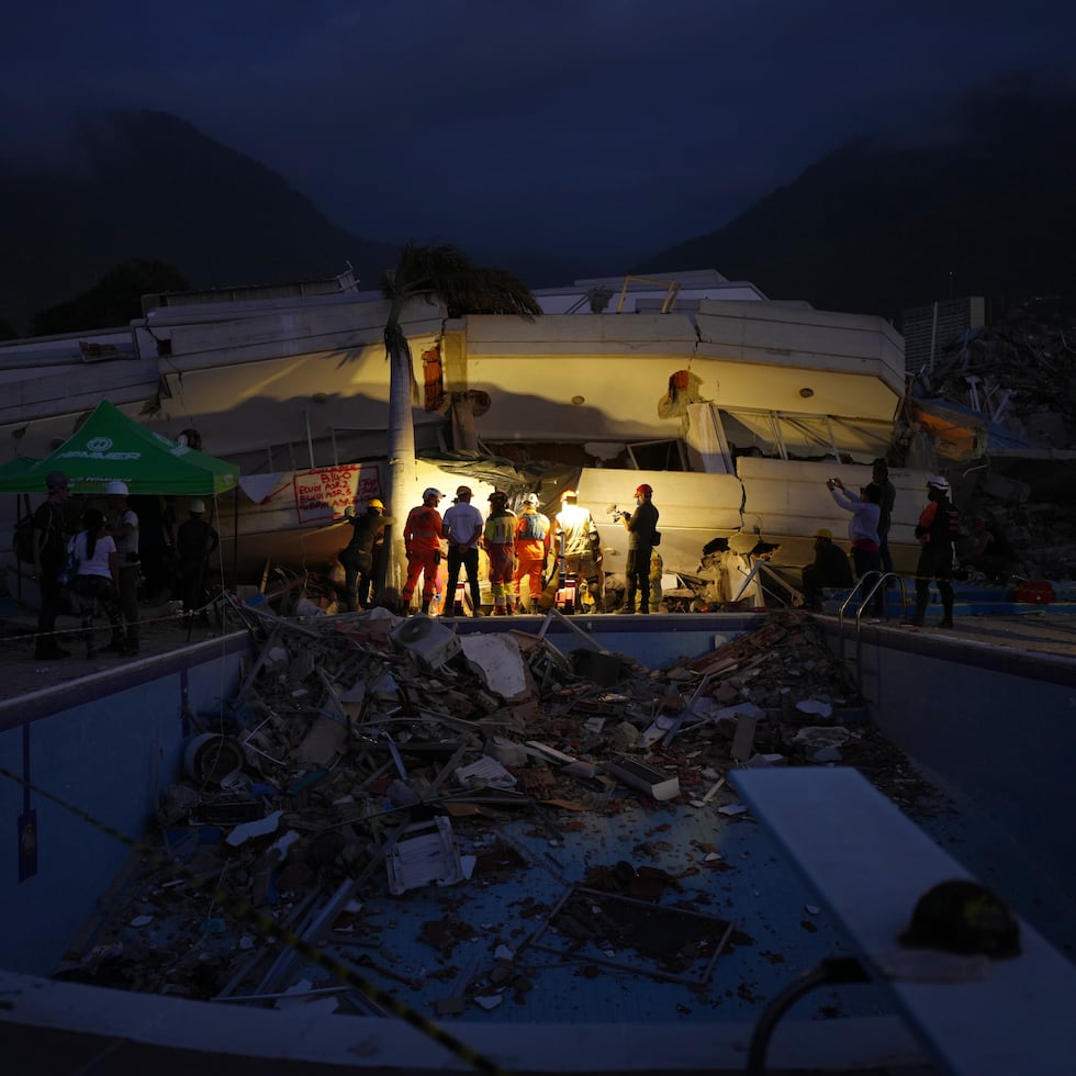 Rescatistas inspeccionan un edificio que colapsó en La Guaira.