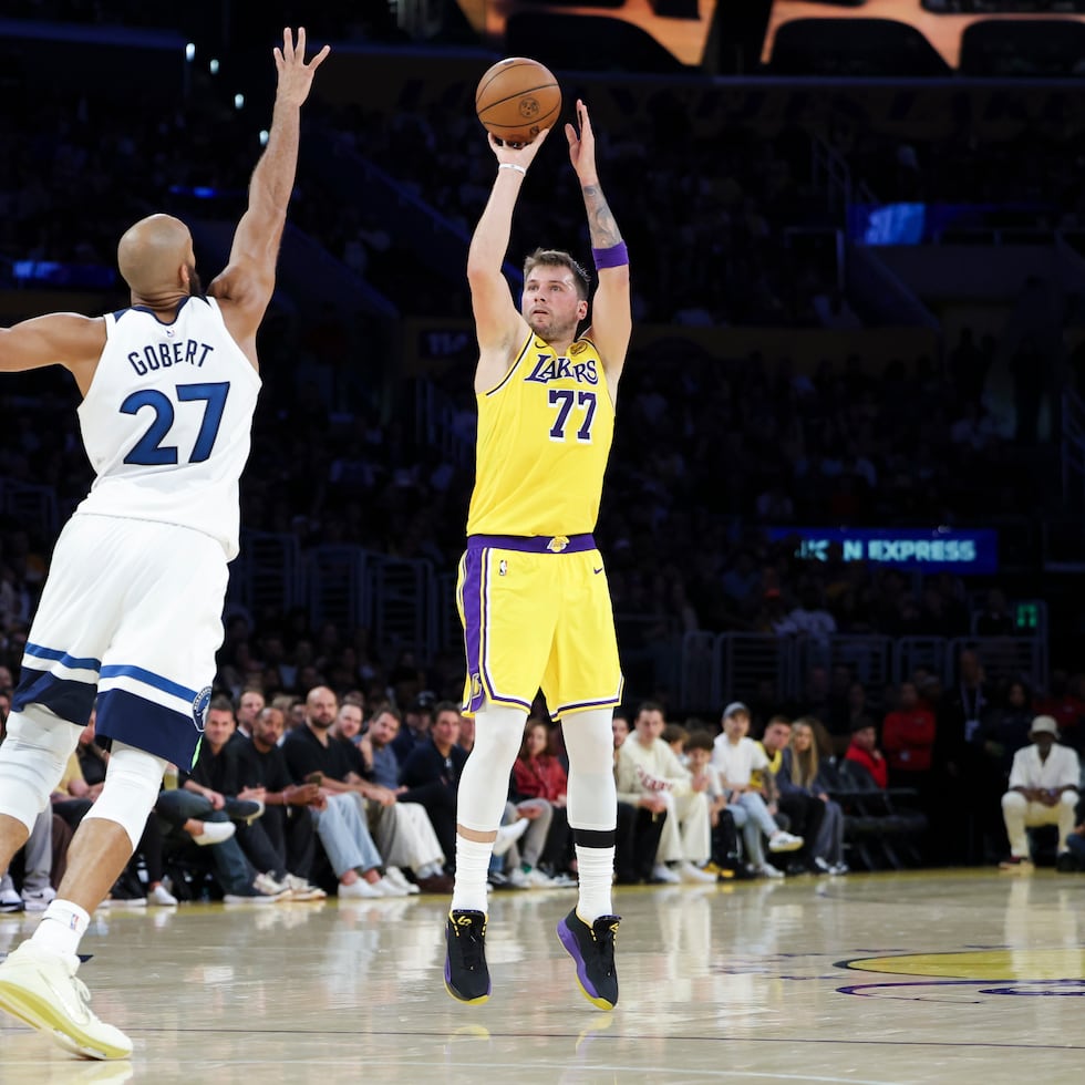 Luka Doncic, de los Lakers de Los Ángeles, dispara desde larga distancia frente a Rudy Gobert, de los Timberwolves de Minnesota.