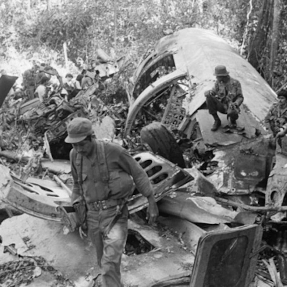 Soldados sandinistas caminan entre restos tras derribar un avión de suministro de los rebeldes con apoyo estadounidense en Loma El Arenal, Nicaragua, en 24 de enero de 1988.