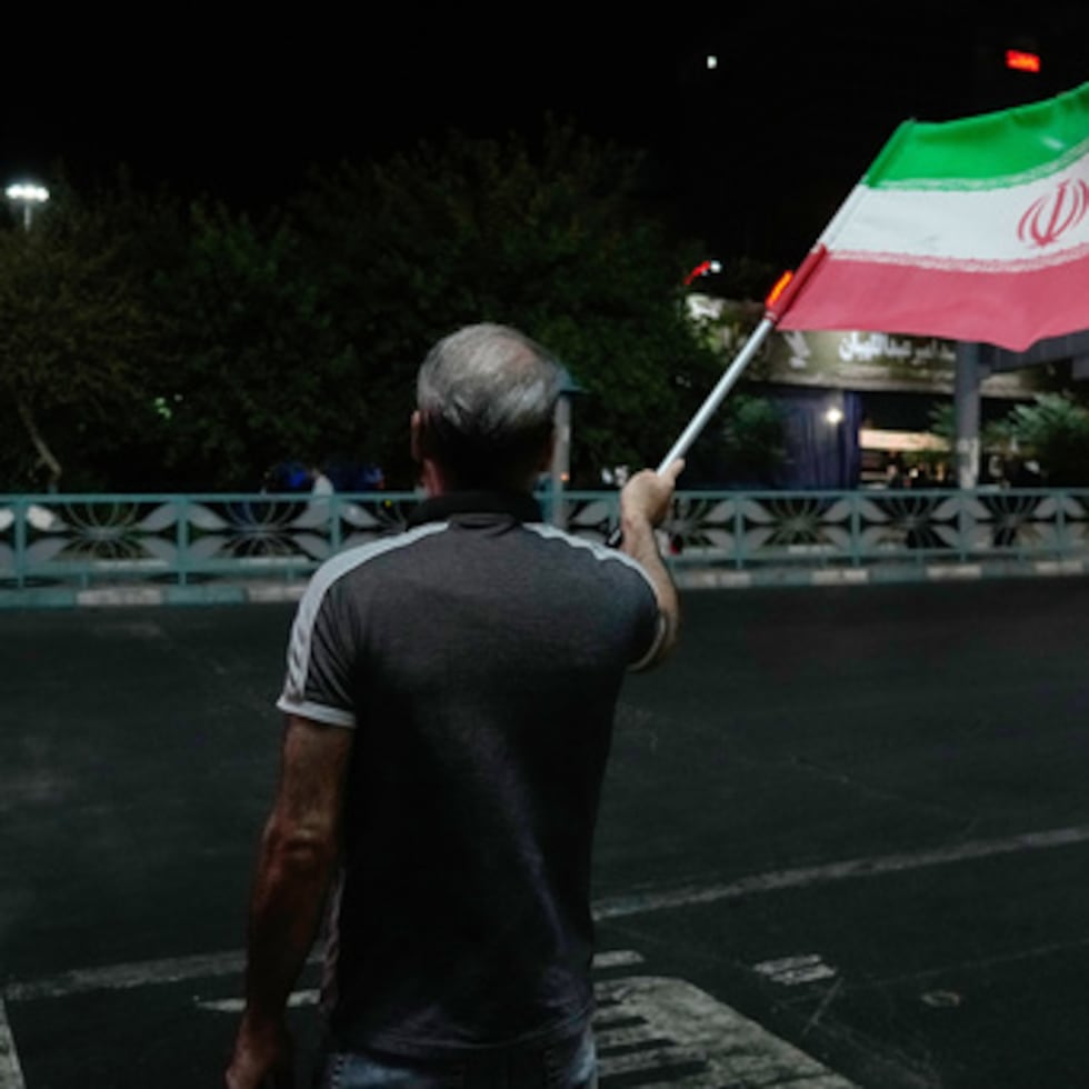 Un manifestante progubernamental ondea la bandera iraní durante una marcha en memoria del difunto líder supremo del país, el ayatolá Ali Jamenei.