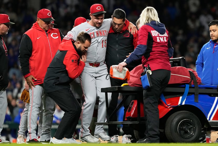 Emilio Pagán es ayudado por personal del equipo de los Reds para salir del terreno el 5 de mayo.