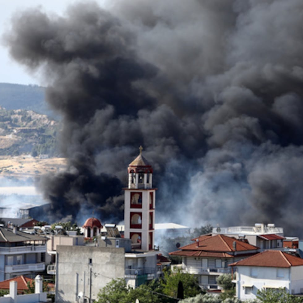 Un denso humo se eleva sobre el asentamiento de Filothei durante un incendio forestal en las afueras de la ciudad de Tesalónica, al norte de Grecia.