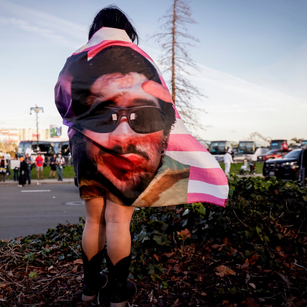 Kenia Medal lleva una bandera de Bad Bunny mientras esperaba para ver el espectáculo de medio tiempo afuera del Levi's Stadium durante el Super Bowl 60 de la NFL.