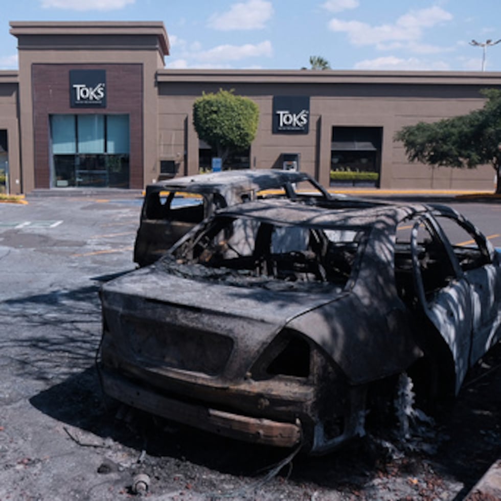 Vehículos calcinados yacen en un estacionamiento frente a un centro comercial en Guadalajara, luego de que las autoridades informaron que el Ejército mexicano abatió al líder del Cártel Jalisco Nueva Generación, Nemesio Oseguera, alias "El Mencho".