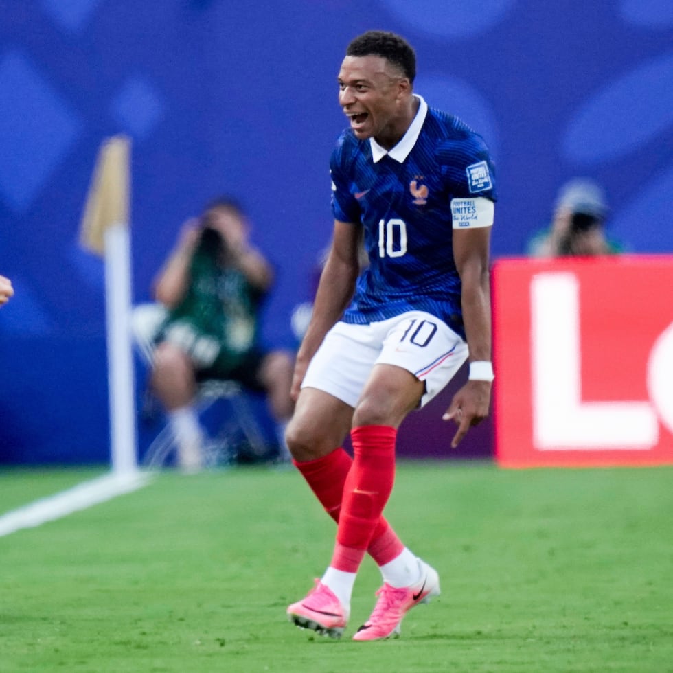 Kylian Mbappé festaja con el técnico Didier Deschamps tras marcar el primer gol de Francia en el partido contra Suecia.