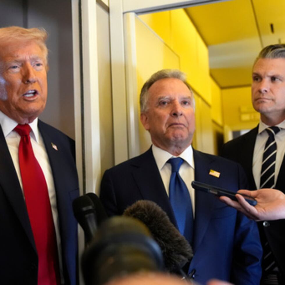 El presidente Donald Trump habla con los periodistas mientras el enviado especial de la Casa Blanca para Oriente Medio, Steve Witkoff, en el centro, y el secretario de Defensa, Pete Hegseth, escuchan mientras viajan a bordo del Air Force One en ruta desde la Base Aérea de Dover, Delaware, a Miami.