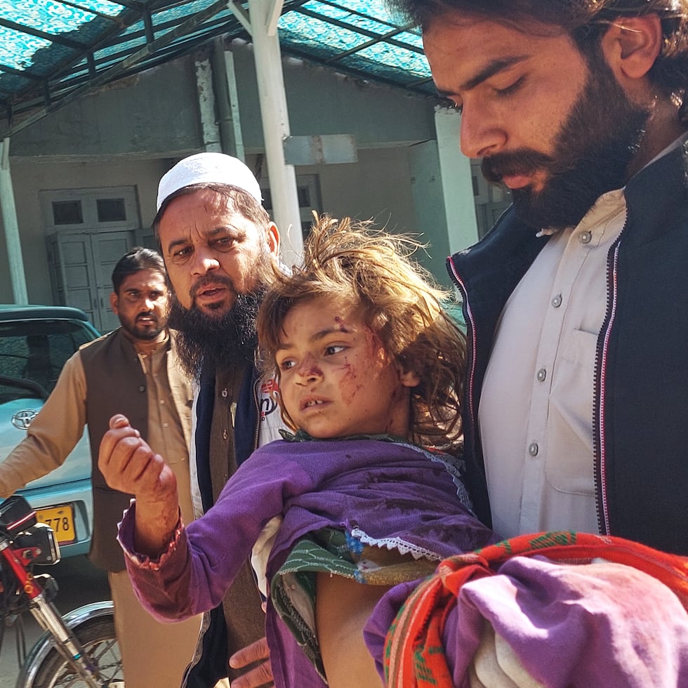 Un hombre carga a una niña que resultó herida en la explosión de una bomba en el noroeste de Pakistán.