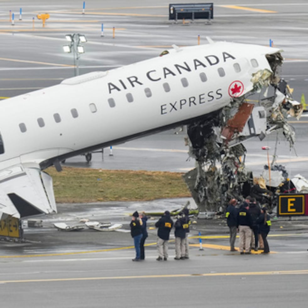 Funcionarios de la Junta Nacional de Seguridad en el Transporte investigan el lugar, el lunes 23 de marzo de 2026, donde un avión de Air Canada se detuvo tras colisionar con un camión de bomberos de la Autoridad Portuaria en el aeropuerto de LaGuardia, poco después de aterrizar el domingo por la noche en Nueva York. (AP Photo/Seth Wenig)