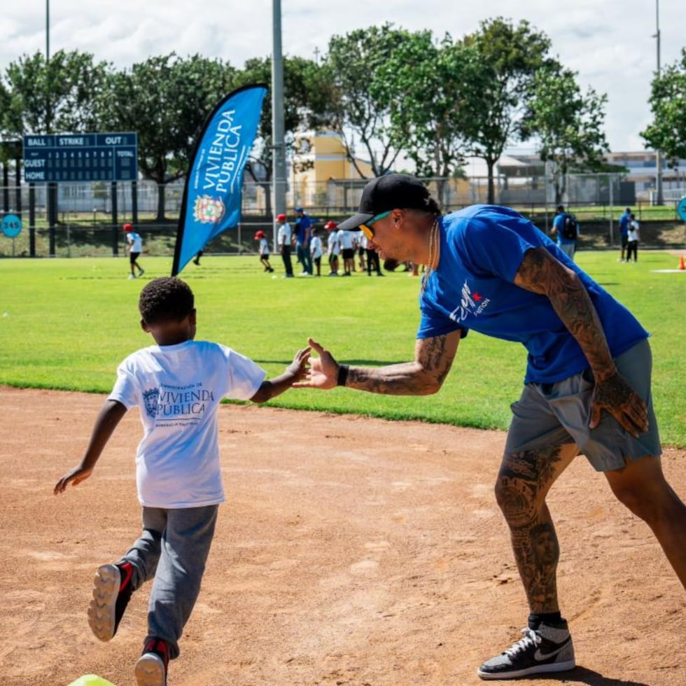 El campocorto de los Tigers de Detroit, Javier Báez, comparte con un niño durante una clínica de béisbol en Bayamón.