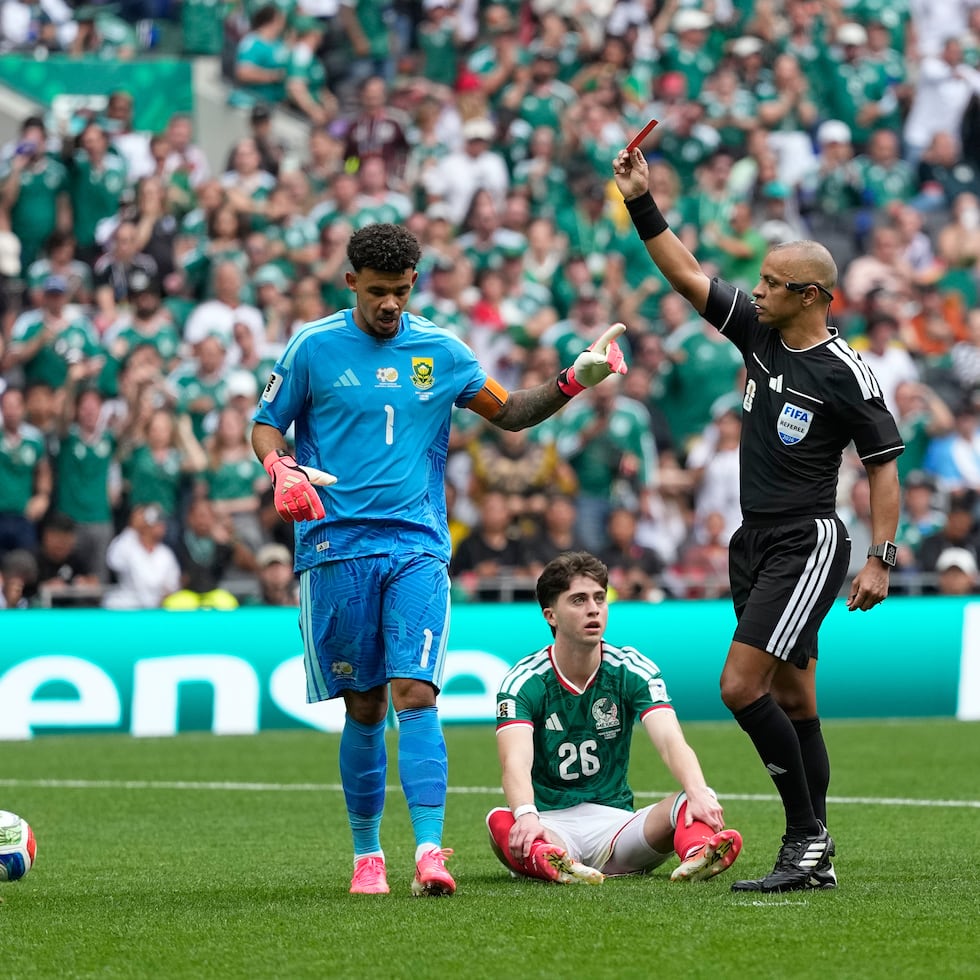 El árbitro Wilton Sampaio expulsa al sudafricano Sphephelo Sithole (izquierda) durante el partido entre México y Sudáfrica por el Grupo A del Mundial.