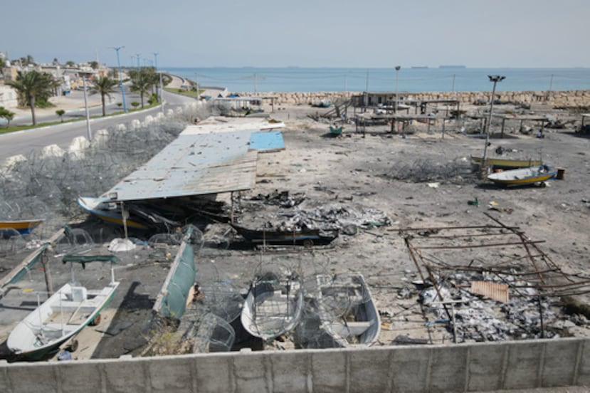 Con el telón de fondo de los barcos en el Estrecho de Ormuz, los daños, según testigos locales causados por varios ataques aéreos recientes durante la campaña militar de EE.UU. e Israel, se ve en un muelle de pesca en el puerto de la isla de Qeshm, Irán, lunes, 13 de abril de 2026. (Foto AP/Asghar Besharati)