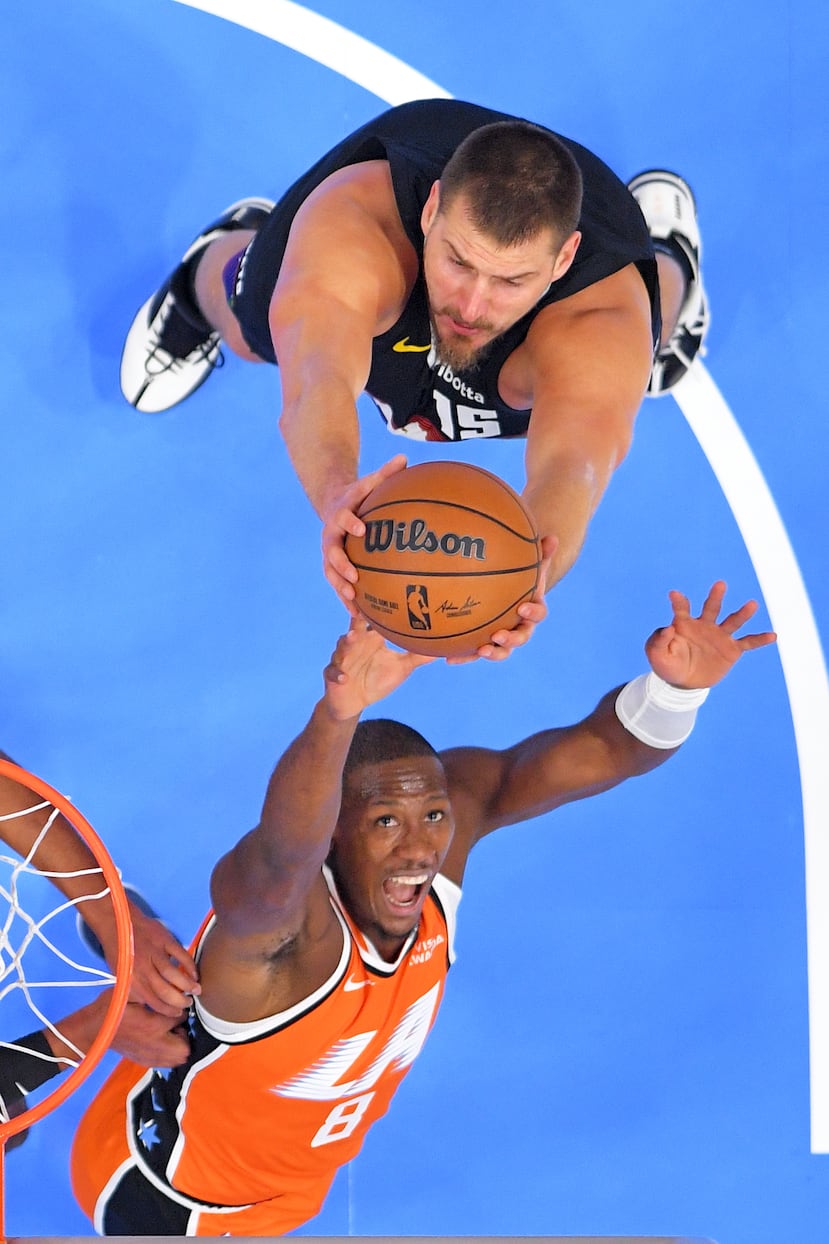 Nikola Jokic se queda con un rebote por encima de Kris Dunn.