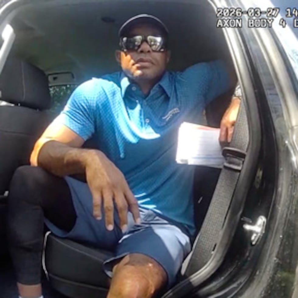 ARCHIVO - En esta imagen extraída del vídeo de la cámara corporal de un agente de policía, difundida por la Oficina del Sheriff del condado de Martin (Florida), el golfista Tiger Woods aparece sentado en un vehículo policial camuflado mientras habla con los agentes tras un accidente de tráfico ocurrido en Jupiter Island (Florida) el 27 de marzo de 2026. (Oficina del sheriff del condado de Martin a través de AP, archivo)