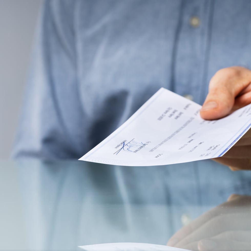 Una imagen de archivo de un hombre sujetando un cheque.