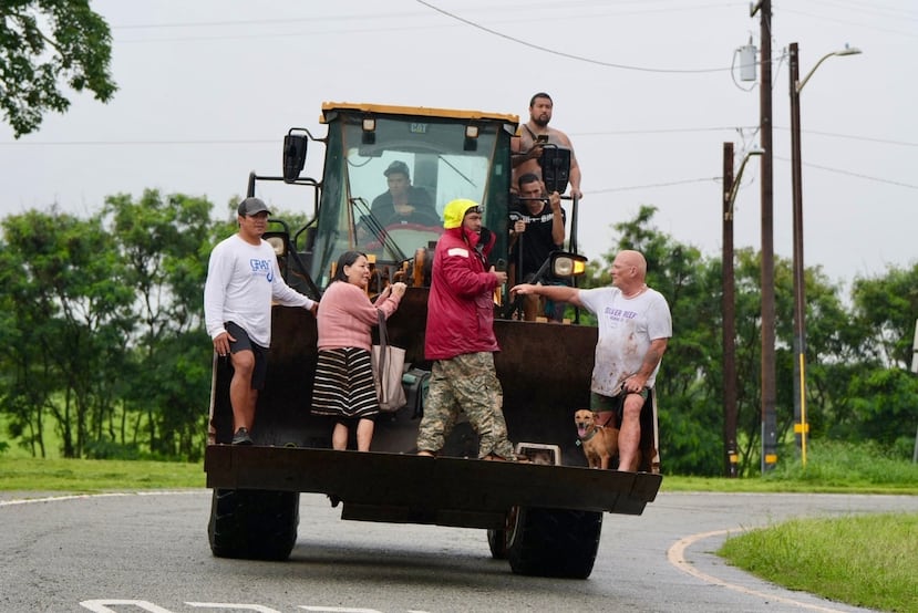 El viernes 20 de marzo de 2026, personas fueron evacuadas de Haleiwa, Hawái, en una excavadora. (Craig Fujii/Hawaii Civil Beat vía AP)