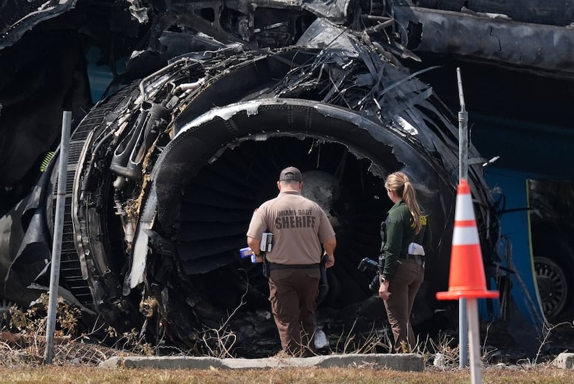 Agentes de la ley caminan frente a un motor destruido mientras inspeccionan un avión de carga de Amazon dos días después de que se saliera de la pista en el Aeropuerto Internacional de Miami, el martes 8 de septiembre de 2026, en Miami. (Foto AP/Rebecca Blackwell)