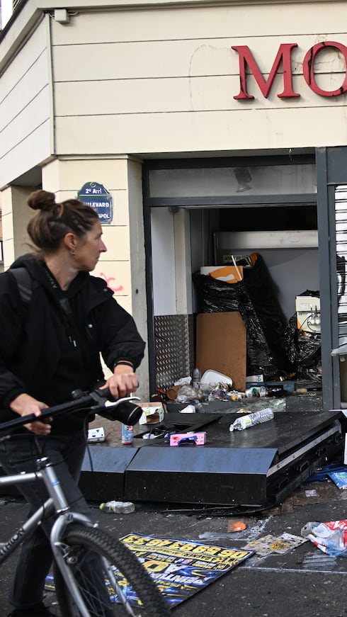 Un hombre camina frente a un comercio saqueado en París, el domingo 18 de octubre de 2026, un día después de la intensa manifestación contra el aumento del costo de vida.