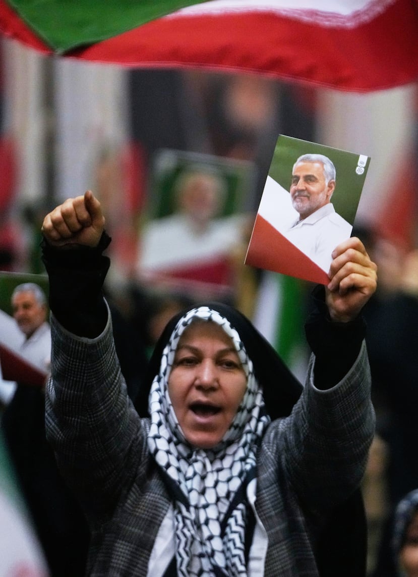Una mujer corea consignas mientras sostiene un cartel del difunto comandante de la Fuerza Quds de la Guardia Revolucionaria de Irán, el general Qassem Soleimani, quien murió en un ataque con drones estadounidenses en 2020 en Irak, durante una ceremonia en conmemoración del aniversario de su muerte en la gran mezquita Imán Jomeini en Teherán, Irán, el jueves 1 de enero de 2026. (Foto AP/Vahid Salemi)