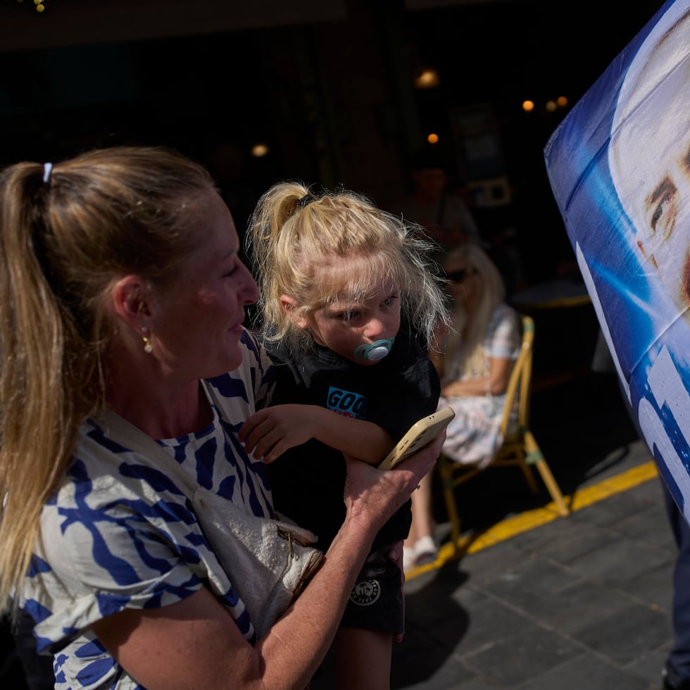 Una mujer y una niña observan un afiche del primer ministro israelí, Benjamin Netanyahu, en Jerusalén, en medio de un clima de tensión política y de incertidumbre sobre el futuro del mandatario, quien enfrenta un juicio por corrupción a pocas semanas de las elecciones nacionales.