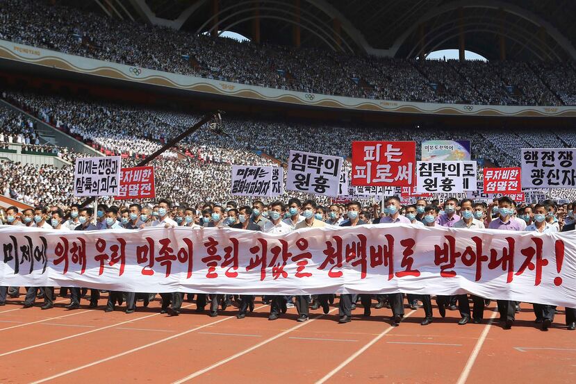 Gente de Pyongyang participa en una manifestación tras una marcha para conmemorar lo que Corea del Norte conoce como "el día de lucha contra el imperialismo estadounidense" en el Estadio del Primero de Mayo en Pyongyang, Corea del Norte, el domingo 25 de junio de 2023. El cartel dice "¡Hagamos que los imperialistas estadounidenses paguen duramente por la sangre derramada por la nación coreana!", "Estados Unidos es el jefe de la guerra y la masacre", "aniquilación inmisericorde", "Estados Unidos es el destructor de la paz", "jefe de agresión", "sangre por sangre" y "maniaco de guerra nuclear".
