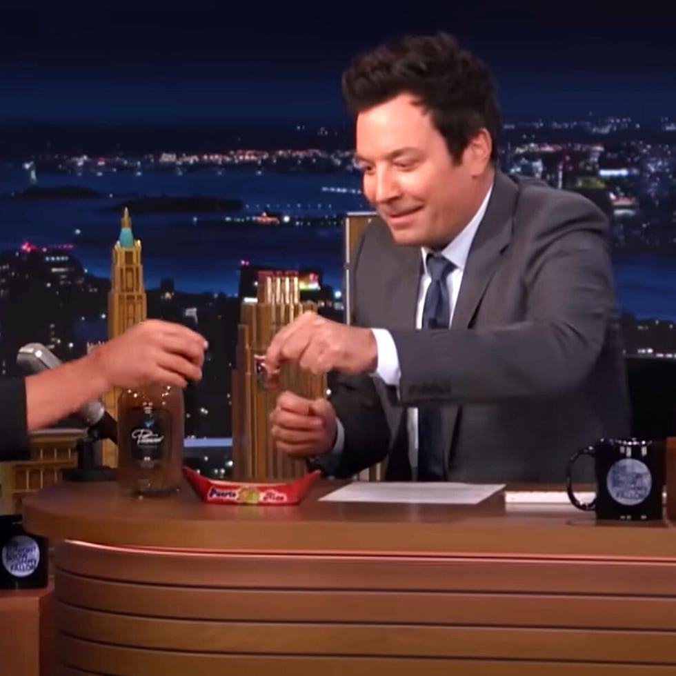 Actor Ramon Rodríguez, left, toasts with host Jimmy Fallon, right, before drinking tamarind pitorro.
