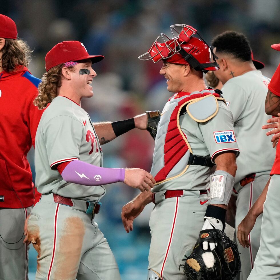Harrison Bader y el receptor J.T. Realmuto celebran luego de que los Phillies derrotaron a los Dodgers para asegurar el título divisional del Este.