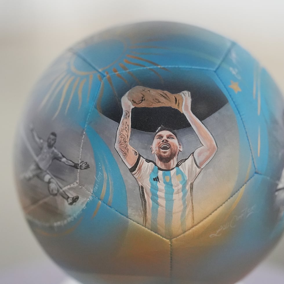 La imagen de Lionel Messi alzando el trofeo del Mundial en un balón pintado a mano por la artista Lili Cantero.