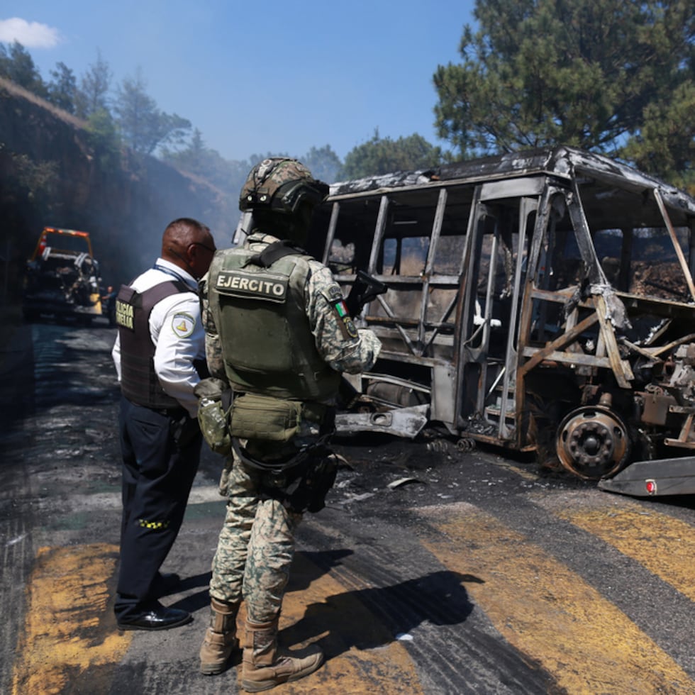 Un soldado vigila junto a un vehículo calcinado que fue incendiado en Cointzio, México, el domingo 22 de febrero de 2026, en medio de informes de que el Ejército mexicano mató al líder del Cártel de Jalisco Nueva Generación, Nemesio Oseguera, conocido como “El Mencho”.