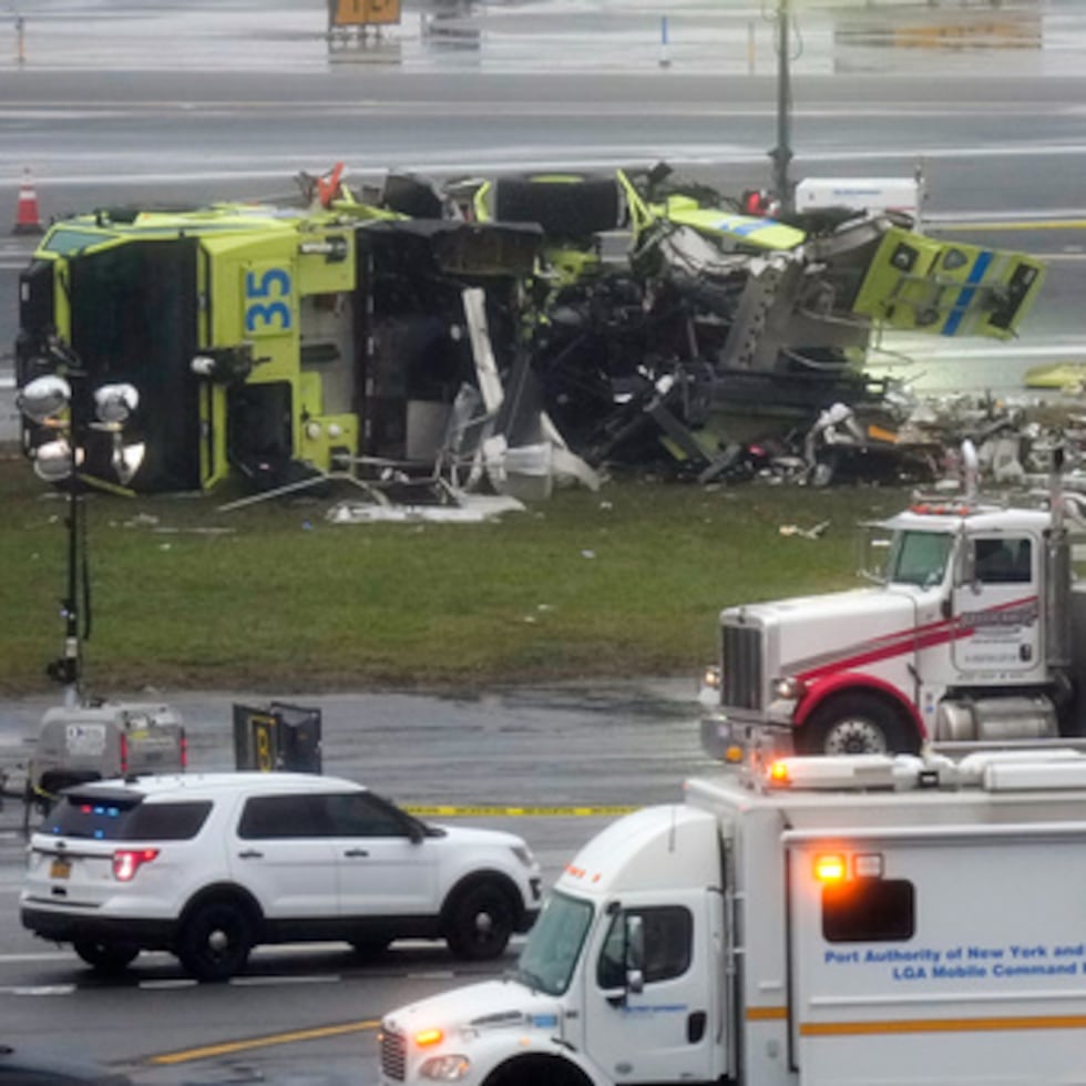 Un camión de bomberos de la Autoridad Portuaria yace de lado justo al lado de la pista de aterrizaje del aeropuerto de LaGuardia, el lunes 23 de marzo de 2026, tras colisionar con un avión de Air Canada poco después de aterrizar a última hora de la noche del domingo en Nueva York. (AP Photo/Seth Wenig)